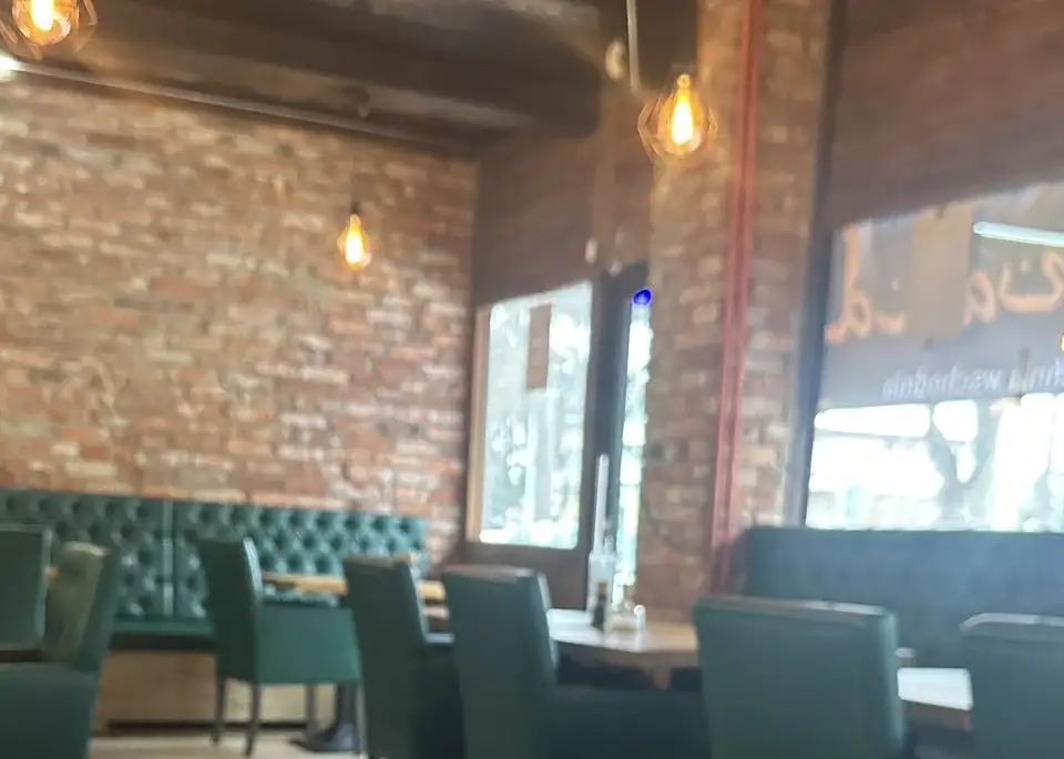 Sala z ceglaną ścianą i zielonymi lożami